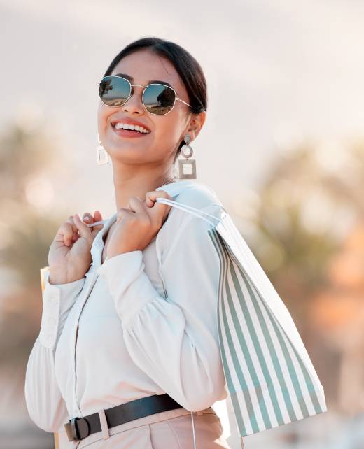 Fashion, style and shopping bags with a woman luxury sunglasses on an urban city street enjoying travel. Stylish, tourism and rich arab female customer or tourist happy about sale discount purchase